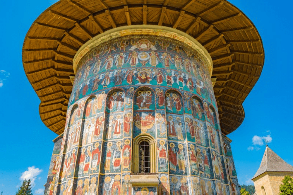 Mănăstire pictată din regiunea Bucovina, care evidențiază frescele vibrante și arhitectura tradițională.